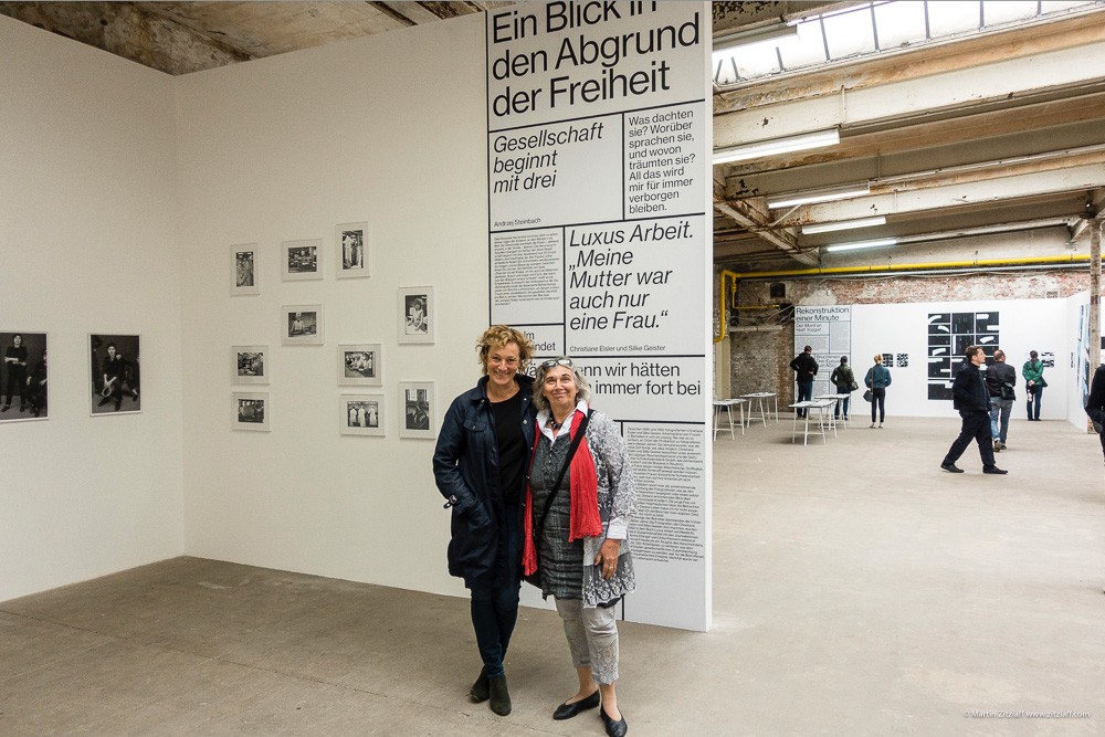 Fotografinnen Silke Geister (li) und Christiane Eisler (re) vor ihren Arbeiten aus "Luxus Arbeit" in der Ausstellung "Zerrissene Gesellschaft" im Rahmen von f-stop, Leipzig, 2018. © Martin Zitzlaff www.zitzlaff.com
